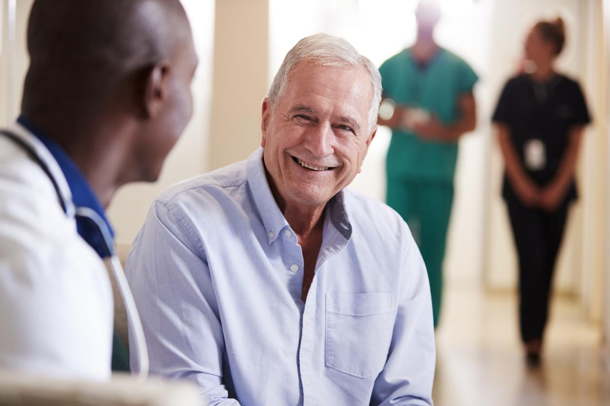 Doctor Welcoming To Senior Male Patient Being Admitted To Hospital, wondering What is a Community Health Center.