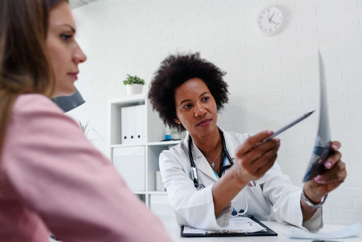 Female doctor looking at test results of her patient. Breast examination. Mammogram. Health care concept, medical insurance., discussing Breast Cancer Awareness and Prevention.