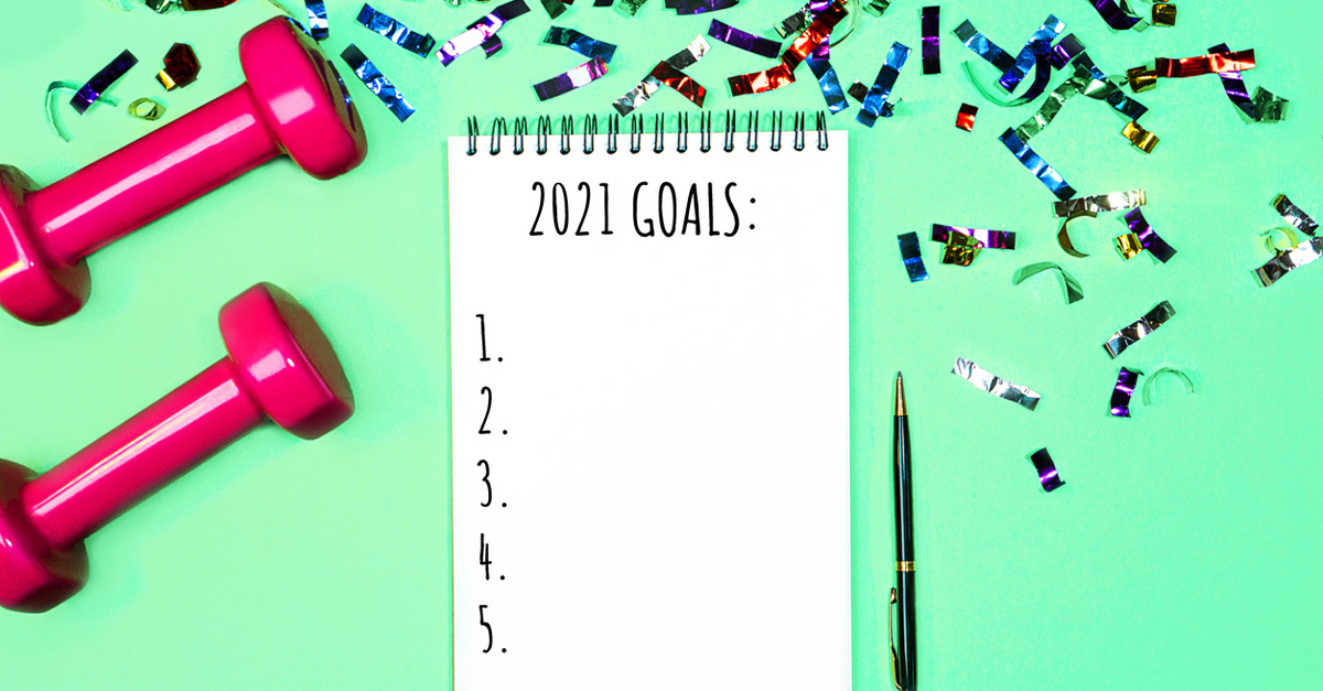 A notepad sayinh "2021 Goals" with weights and confetti