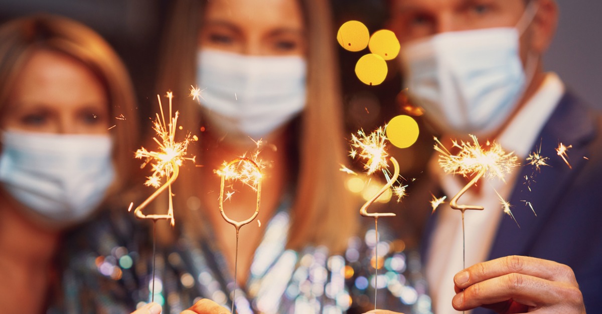 Young friends in masks with 2022 sparklers