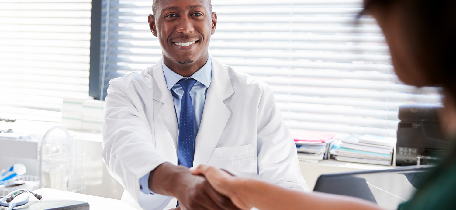 Doctor handshaking his patient.