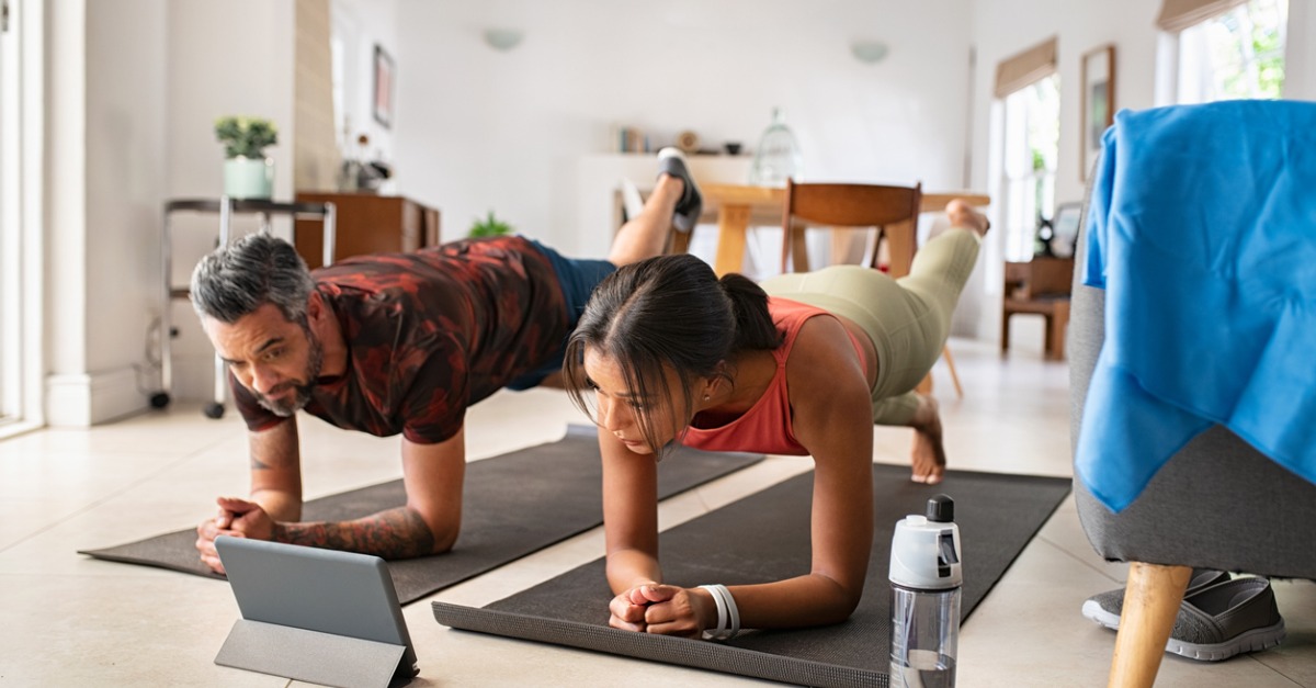 Mixed race couple doing yoga at home