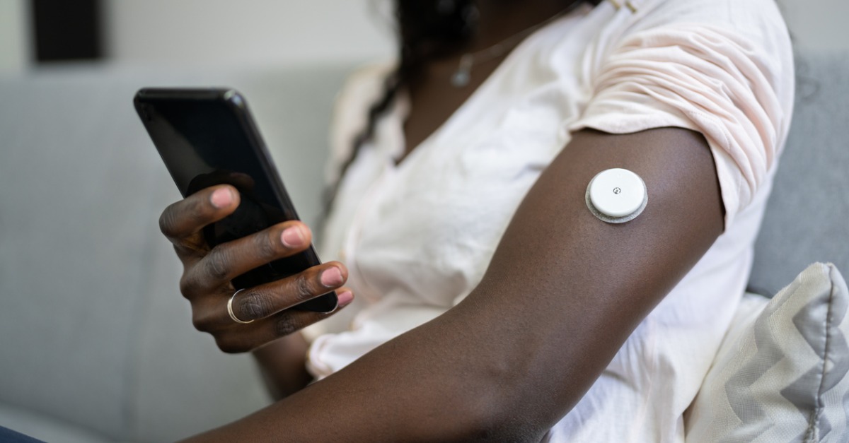 African woman with diabetes monitor on arm