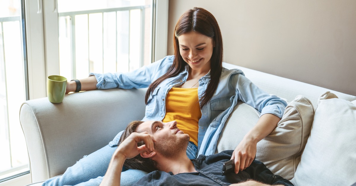 Happy couple at home sitting on couch