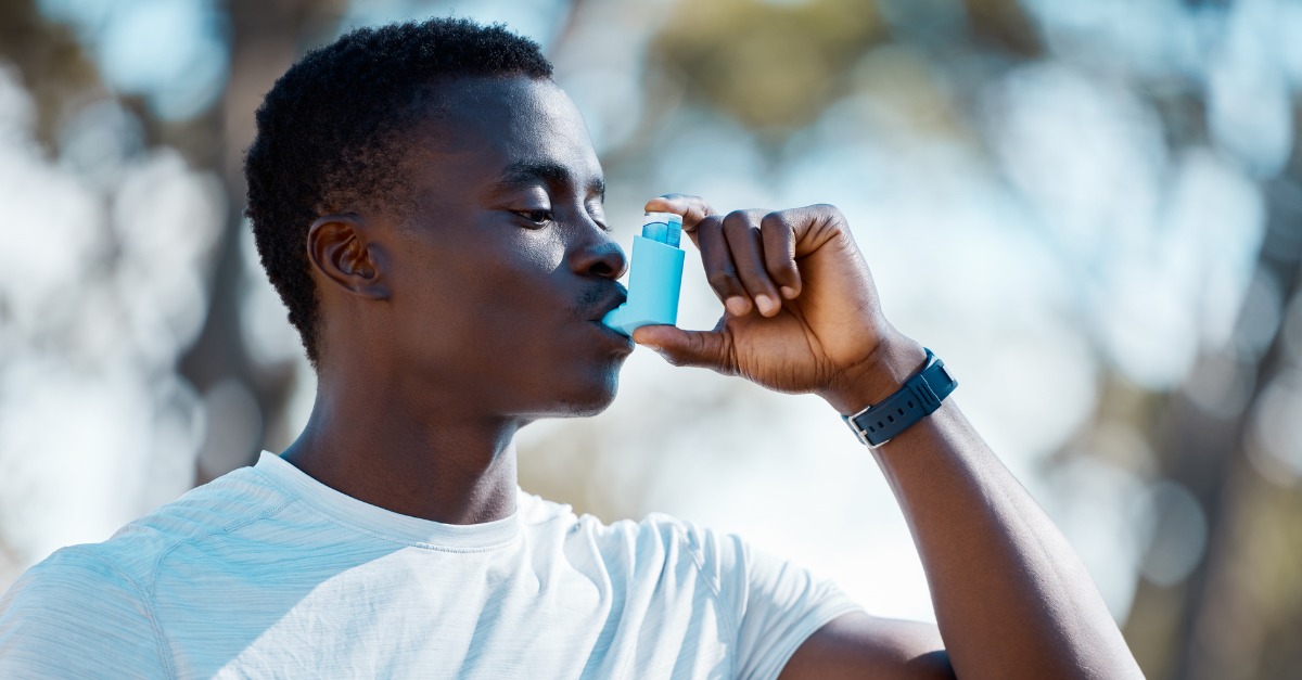 Young African Man taking a pump from asthma inhaler