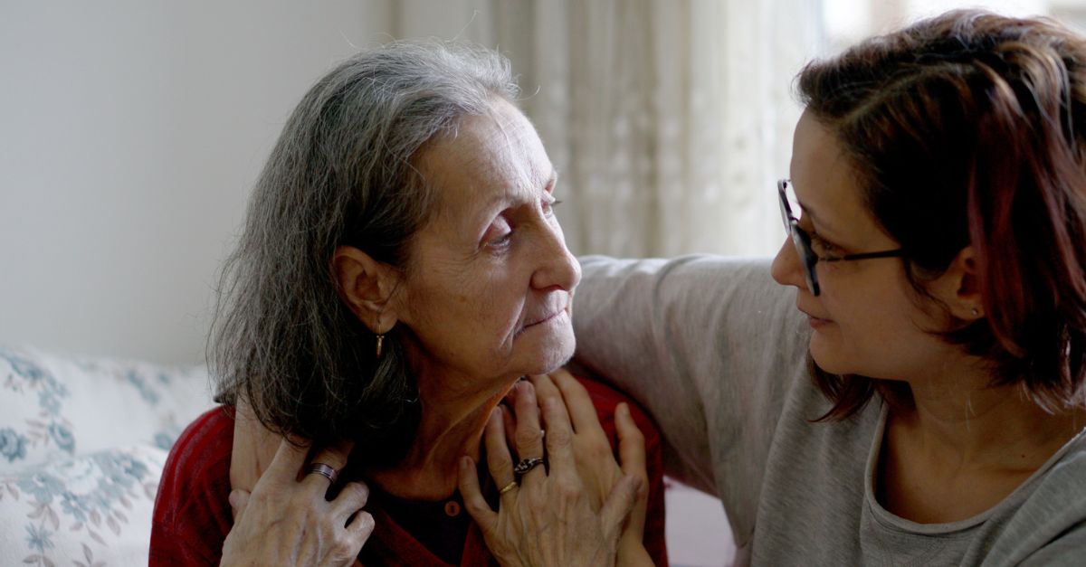 Woman in glasses hugging her elderly mother