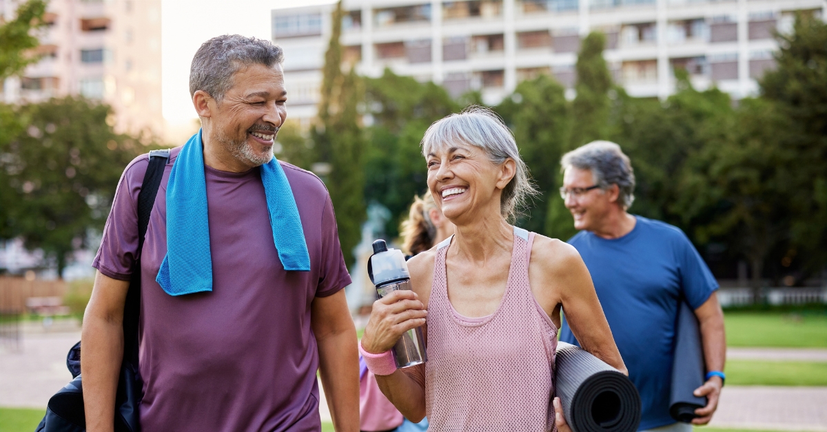 Happy elderly couple walking after exercising in a city park